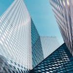 Futuristic skyscrapers in Vilnius with reflective geometric facades under a clear sky.